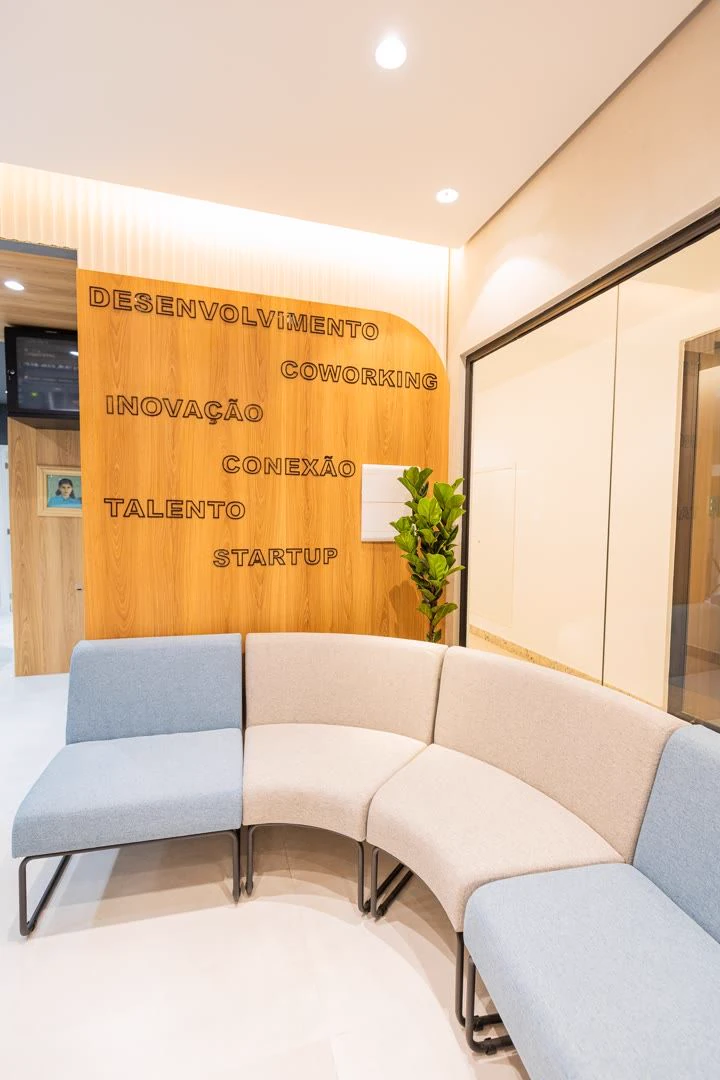 Lounge do coworking da unidade Coroa do Meio, com parede COWORKING
